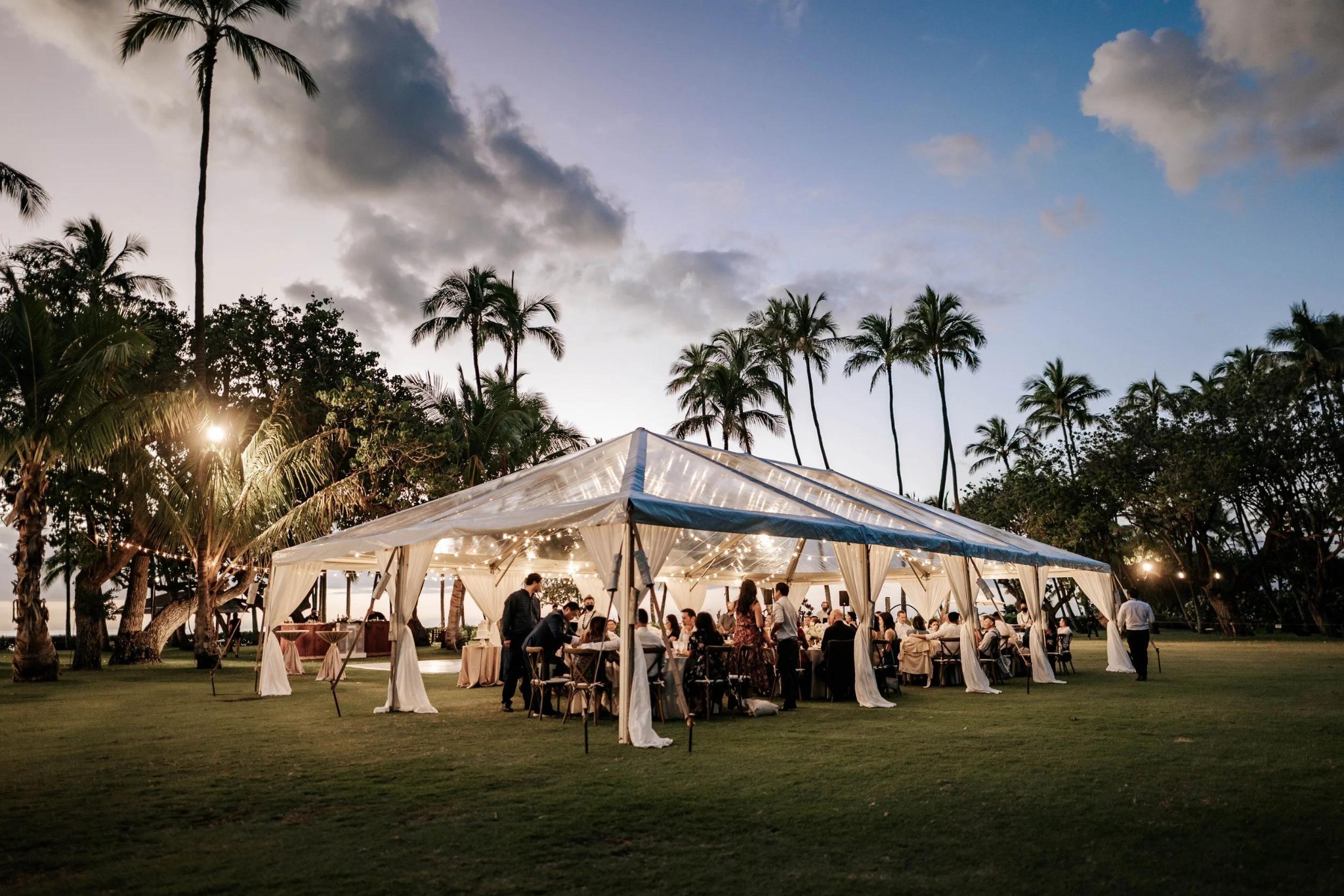 Outdoor reception with draped canopy and decorated tables